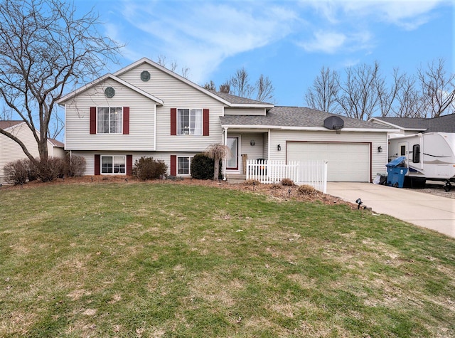 split level home with a garage, a shingled roof, concrete driveway, and a front yard