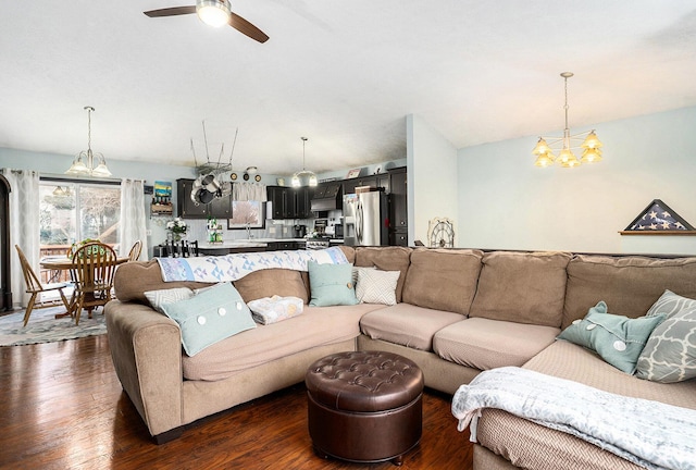 living room featuring dark wood-style flooring and ceiling fan with notable chandelier