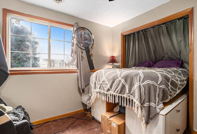 bedroom with wood finished floors and baseboards