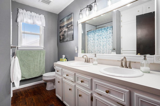 full bath featuring visible vents, a sink, toilet, and wood finished floors