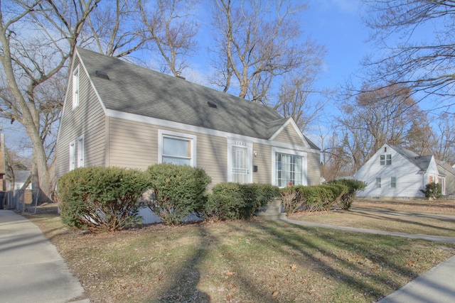 view of front of home featuring a shingled roof and a front lawn