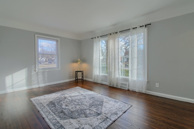 unfurnished room with hardwood / wood-style flooring and baseboards