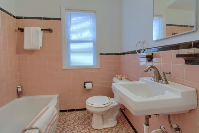 full bathroom with a tub to relax in, a sink, tile walls, and toilet