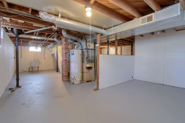 basement with water heater, visible vents, and heating unit