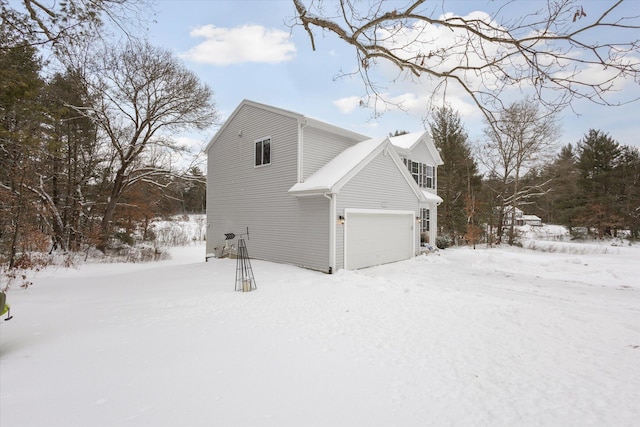 snow covered property with an attached garage