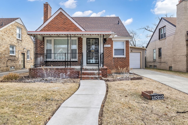 bungalow-style house with brick siding, a chimney, a porch, a garage, and driveway