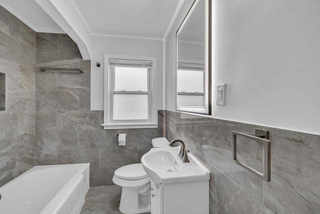 full bathroom with a tub to relax in, toilet, crown molding, vanity, and tile walls