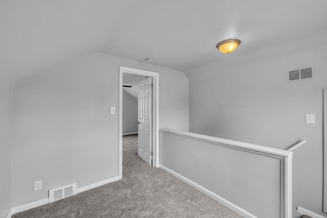 interior space with carpet floors, visible vents, and vaulted ceiling