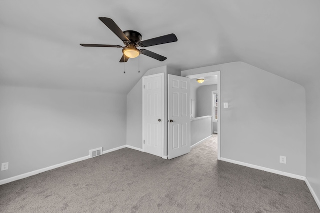 bonus room featuring carpet floors, baseboards, visible vents, and vaulted ceiling