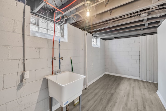 basement with a sink and wood finished floors