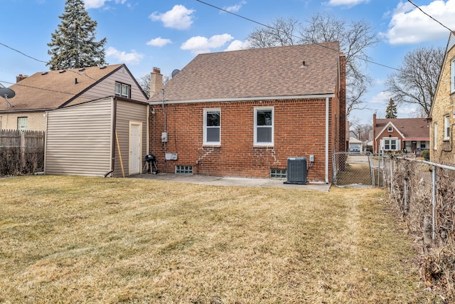 rear view of property with a yard, brick siding, fence, and central air condition unit