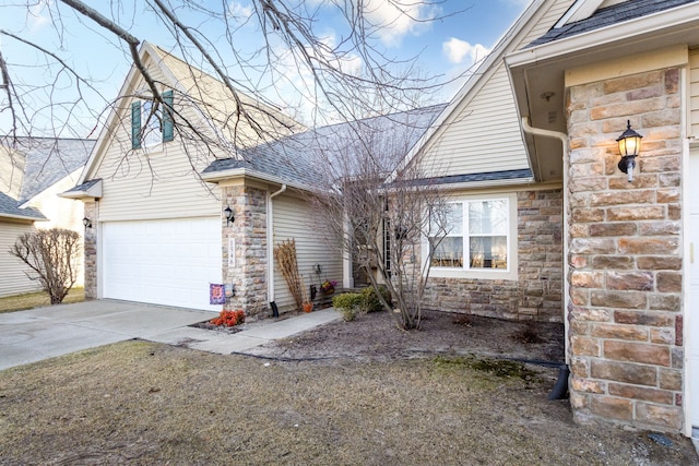 view of front of property featuring stone siding, driveway, a garage, and roof with shingles