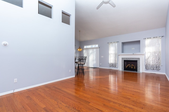 unfurnished living room featuring wood finished floors, a fireplace, and baseboards