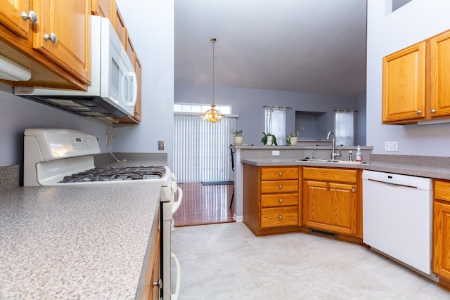 kitchen with white appliances, visible vents, a peninsula, a sink, and light countertops