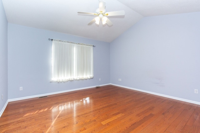 unfurnished room featuring visible vents, lofted ceiling, baseboards, and wood finished floors