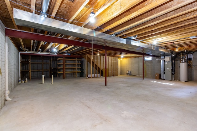 unfinished below grade area featuring gas water heater, heating unit, and brick wall