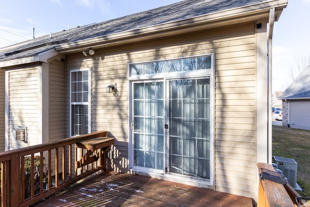 exterior space with a deck and a shingled roof