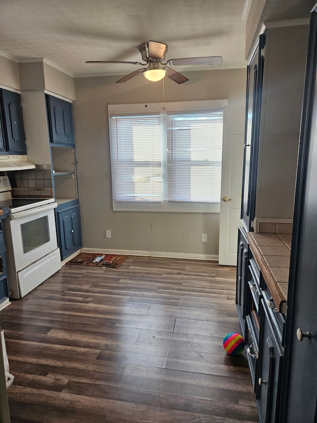 kitchen with white range with electric cooktop, tasteful backsplash, dark wood-type flooring, ornamental molding, and under cabinet range hood