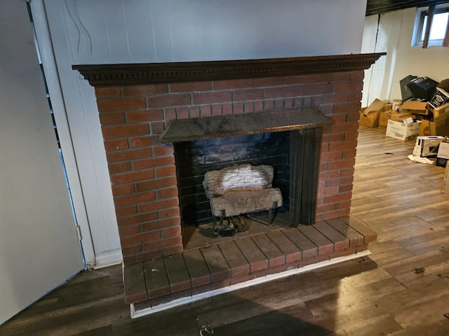 interior details featuring a brick fireplace and wood finished floors