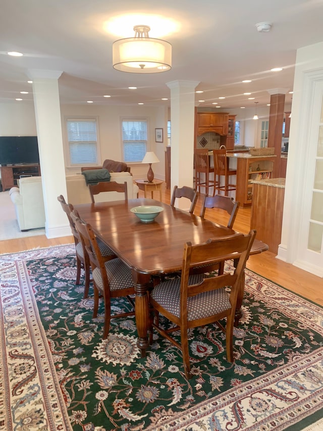 dining area with recessed lighting, light wood-style flooring, and ornate columns