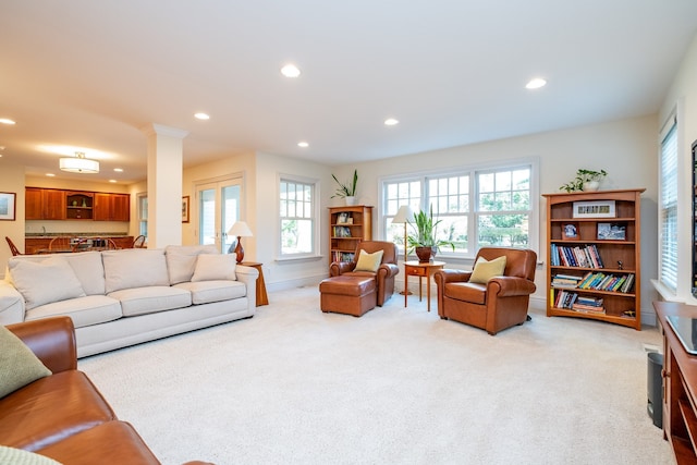 living room featuring light carpet, decorative columns, and recessed lighting