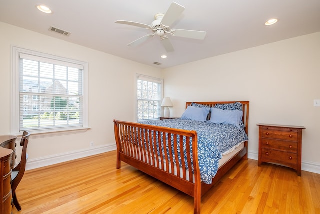 bedroom with recessed lighting, wood finished floors, visible vents, and baseboards