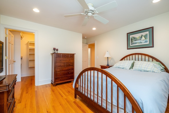 bedroom featuring baseboards, a ceiling fan, a spacious closet, light wood-style floors, and recessed lighting