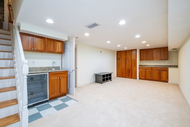 kitchen featuring wine cooler, visible vents, brown cabinetry, and recessed lighting