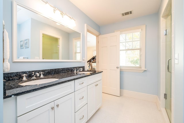 full bath featuring baseboards, a sink, visible vents, and a shower stall