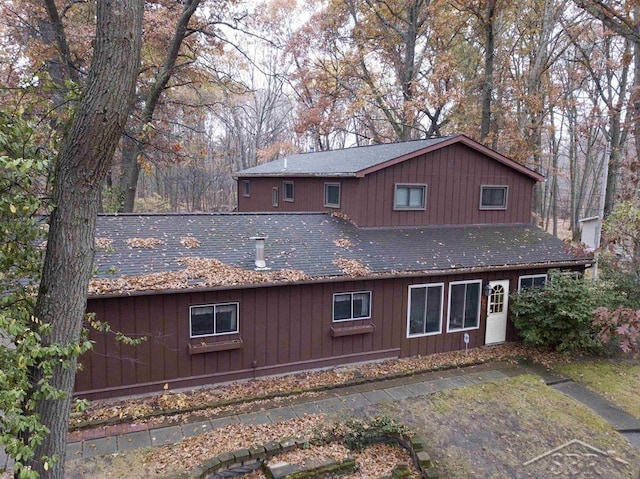 back of property with a shingled roof