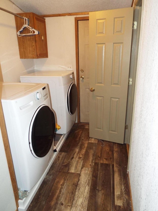 laundry area with cabinet space, a textured ceiling, dark wood-style flooring, and washer and dryer