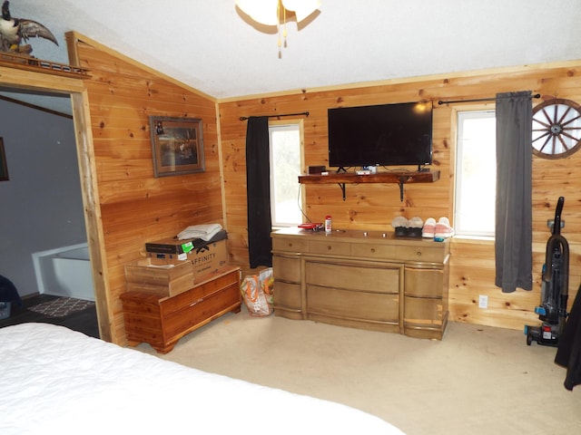 bedroom featuring carpet flooring, vaulted ceiling, and wooden walls