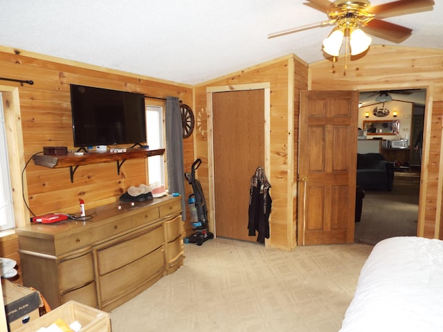 bedroom featuring light colored carpet, vaulted ceiling, and wooden walls