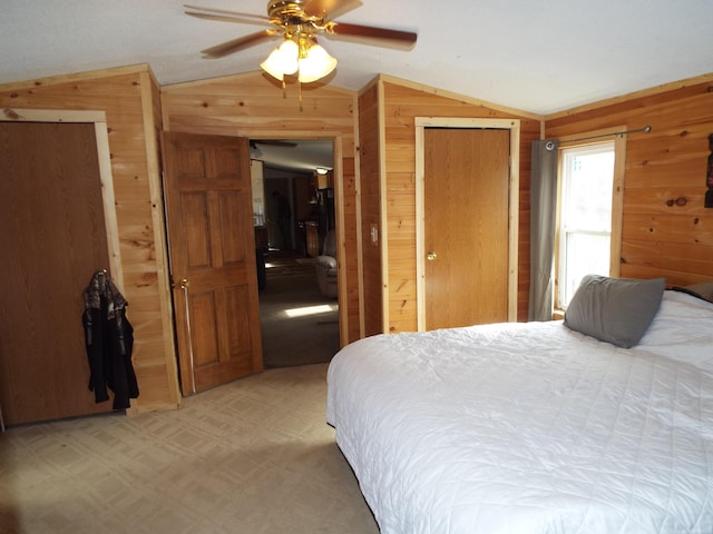 bedroom featuring wood walls, ceiling fan, and vaulted ceiling