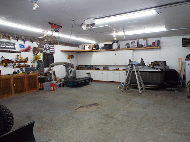 garage with a garage door opener and a workshop area