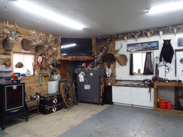 garage featuring wooden walls and a workshop area