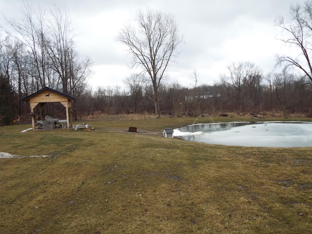 view of yard with a water view, a forest view, and a pool