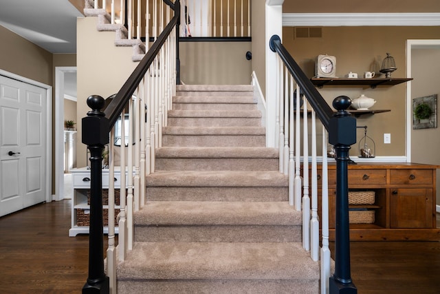 staircase with visible vents and wood finished floors