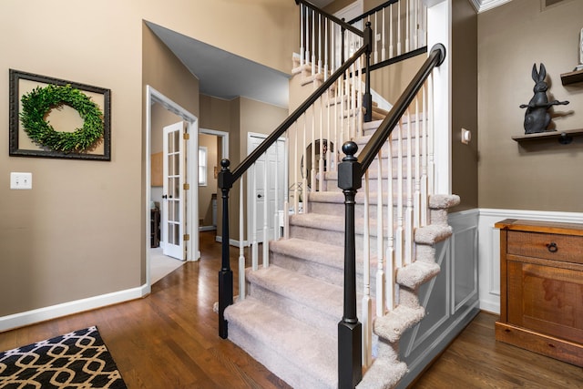 stairs with visible vents, baseboards, a wainscoted wall, french doors, and wood finished floors