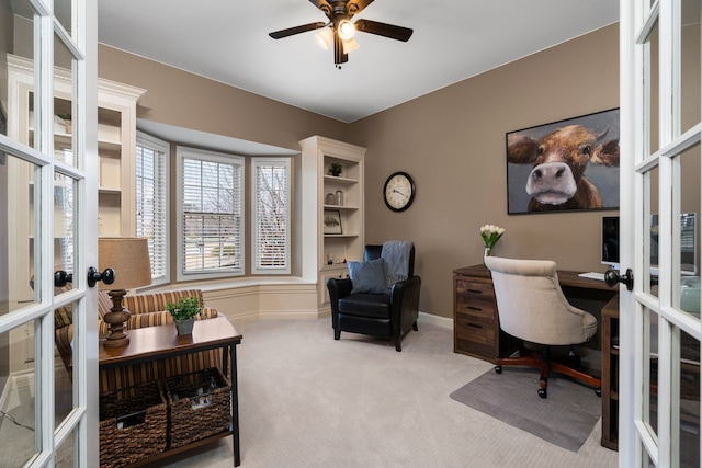 carpeted office space with a ceiling fan, baseboards, and french doors