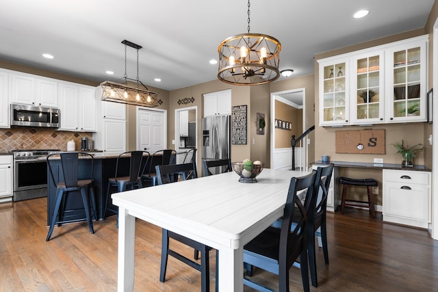 dining space featuring recessed lighting, a chandelier, and dark wood-style flooring