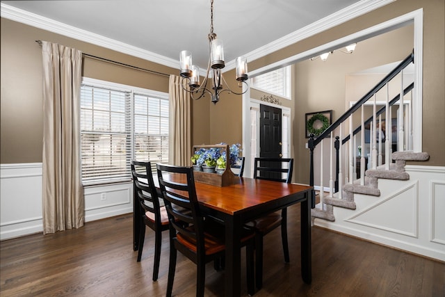 dining space featuring crown molding, dark wood-style floors, a wealth of natural light, and a chandelier