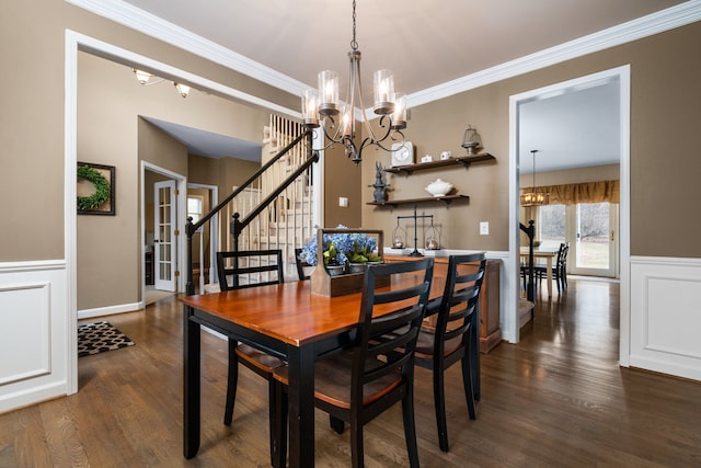 dining room with dark wood-type flooring, a notable chandelier, stairway, wainscoting, and crown molding