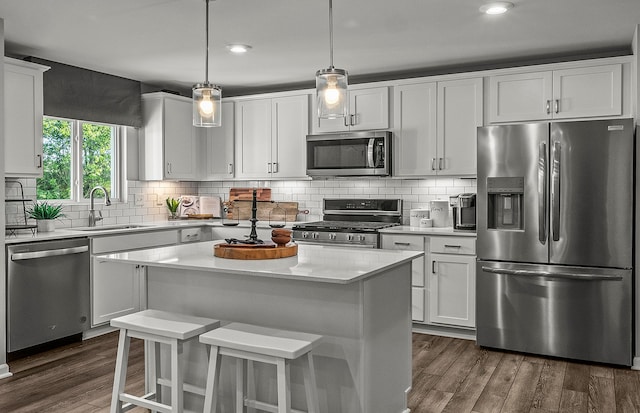 kitchen featuring tasteful backsplash, appliances with stainless steel finishes, white cabinets, and a sink