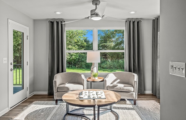 sitting room with ceiling fan, baseboards, and wood finished floors