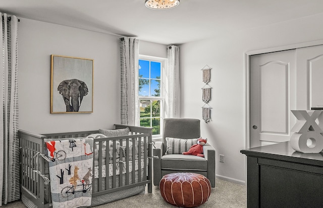 bedroom featuring carpet floors, a crib, and baseboards