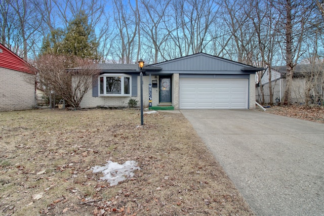 ranch-style house featuring an attached garage, driveway, a chimney, and brick siding