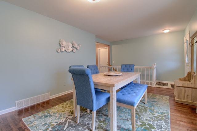 dining space with wood finished floors, visible vents, and baseboards