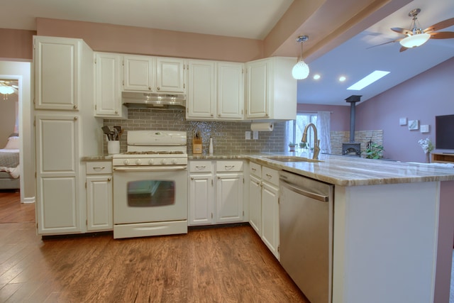 kitchen featuring gas range gas stove, under cabinet range hood, dark wood-style floors, and stainless steel dishwasher