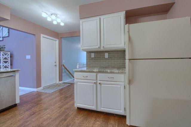 kitchen featuring tasteful backsplash, dark wood-type flooring, freestanding refrigerator, white cabinetry, and baseboards